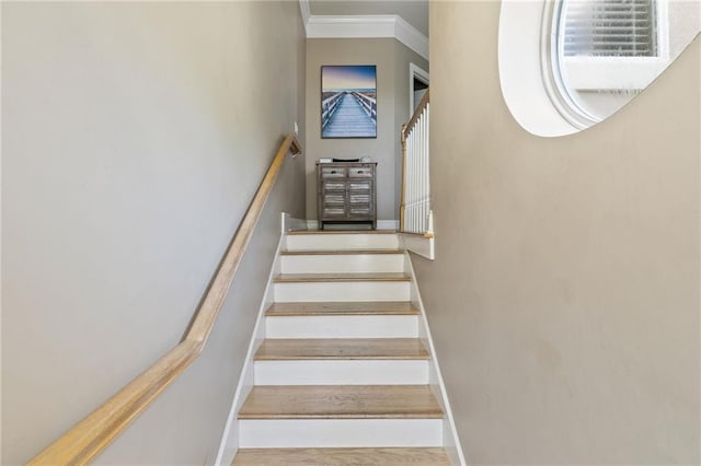 stairs with baseboards, crown molding, and wood finished floors