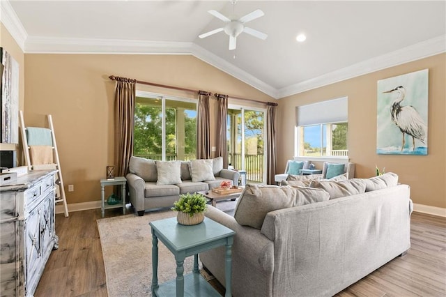 living room with crown molding, plenty of natural light, vaulted ceiling, and wood finished floors