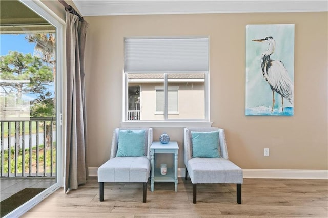 living area with a wealth of natural light, baseboards, and wood finished floors