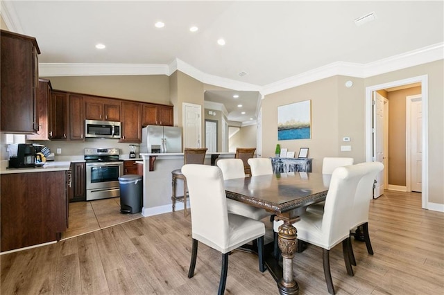 dining area featuring vaulted ceiling, recessed lighting, light wood-type flooring, and crown molding