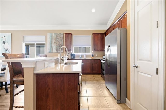 kitchen featuring a breakfast bar area, appliances with stainless steel finishes, ornamental molding, light countertops, and a sink