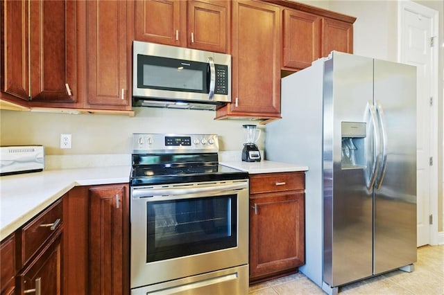 kitchen featuring light tile patterned floors, light countertops, and appliances with stainless steel finishes