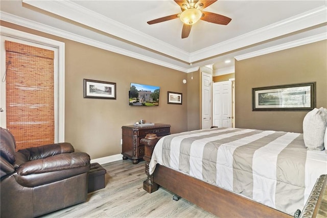 bedroom with a ceiling fan, crown molding, baseboards, and wood finished floors