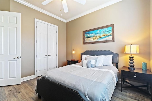 bedroom with ceiling fan, wood finished floors, baseboards, ornamental molding, and a closet