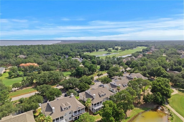 drone / aerial view featuring a water view, a residential view, and a view of trees