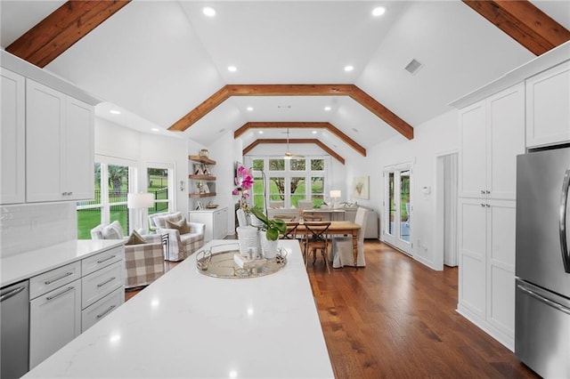 kitchen featuring white cabinetry, vaulted ceiling with beams, a wealth of natural light, and appliances with stainless steel finishes