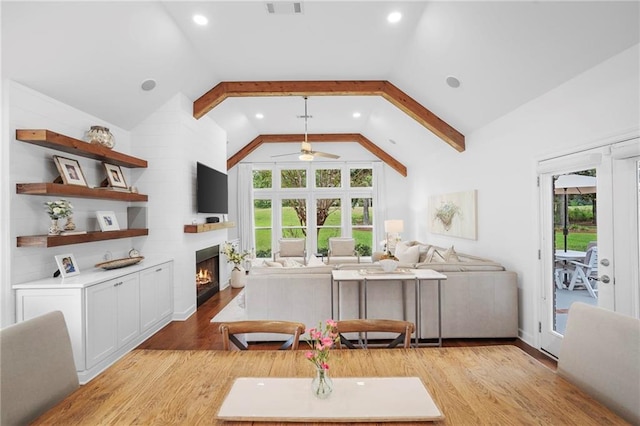 living room with light wood-type flooring, high vaulted ceiling, and ceiling fan