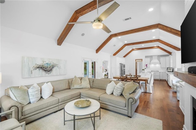 living room with hardwood / wood-style flooring, vaulted ceiling with beams, and ceiling fan