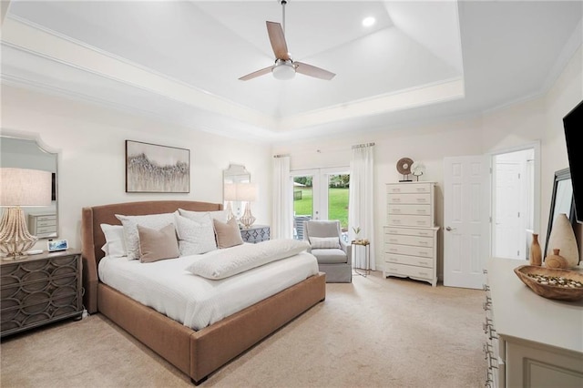 carpeted bedroom with ceiling fan, ornamental molding, and a tray ceiling