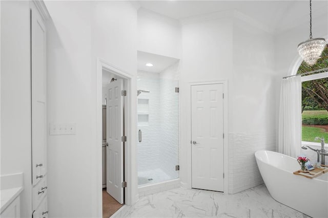 bathroom with ornamental molding, independent shower and bath, and an inviting chandelier