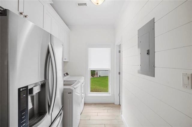 laundry area with light wood-type flooring, electric panel, and independent washer and dryer