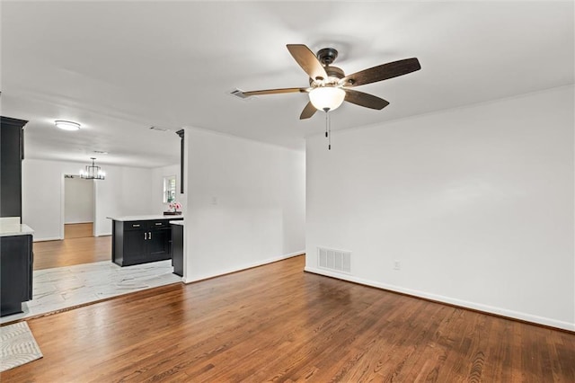 3510 Zimlich Ave, Mobile, AL 36608 - unfurnished living room featuring ceiling fan, light wood-style flooring, and a chandelier