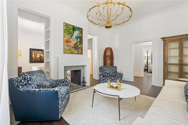 205 George St, Mobile, AL 36604 - living area featuring a chandelier, a fireplace with raised hearth, built in shelves, wood finished floors, and baseboards