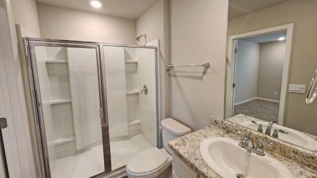 bathroom with a stall shower, vanity, and toilet