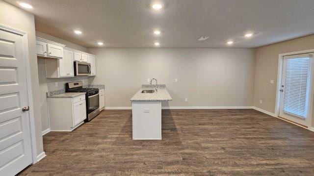 kitchen with recessed lighting, dark wood-type flooring, a sink, white cabinets, and appliances with stainless steel finishes