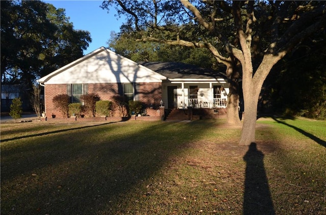 ranch-style house featuring brick siding, a porch, and a front yard