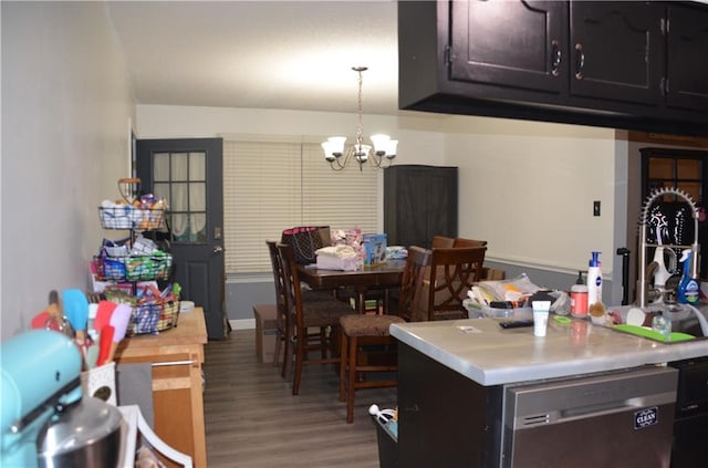 kitchen with a notable chandelier, wood finished floors, light countertops, hanging light fixtures, and dishwasher