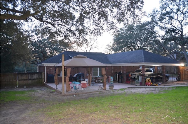 rear view of house featuring a patio area, brick siding, and a gazebo