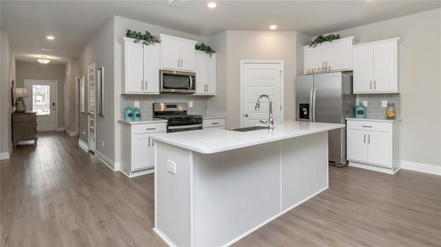 10694 Relic Rd N, Mobile, AL 36608 - kitchen with appliances with stainless steel finishes, an island with sink, decorative backsplash, light countertops, and recessed lighting