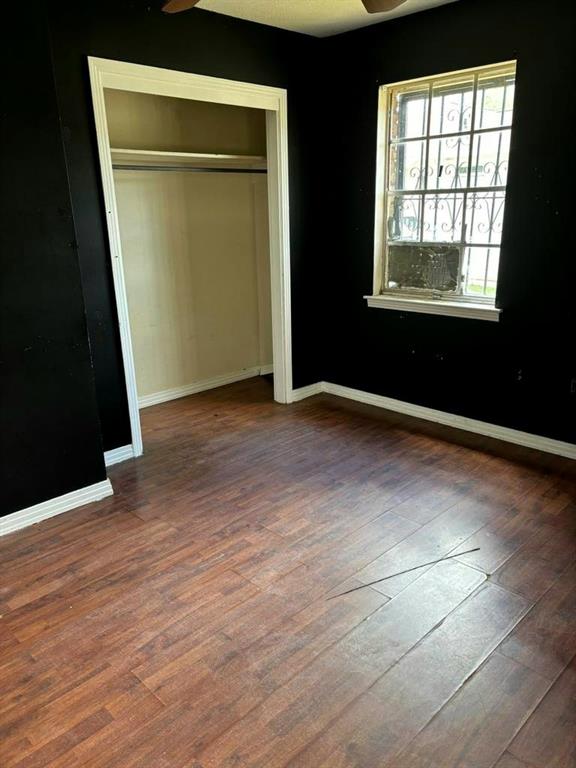 unfurnished bedroom featuring dark hardwood / wood-style flooring and a closet