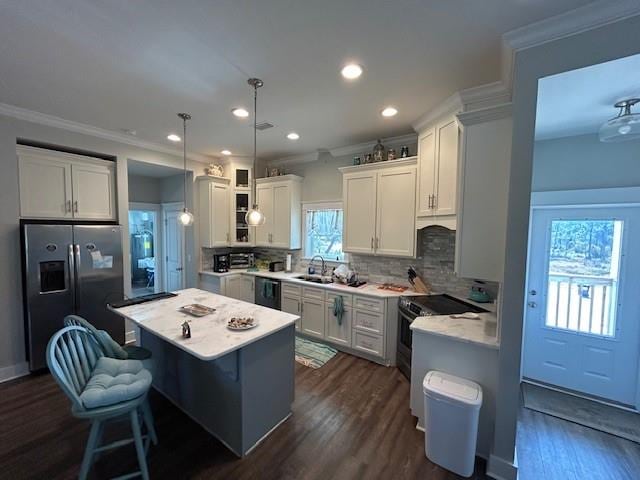 kitchen featuring a healthy amount of sunlight, hanging light fixtures, tasteful backsplash, and stainless steel appliances