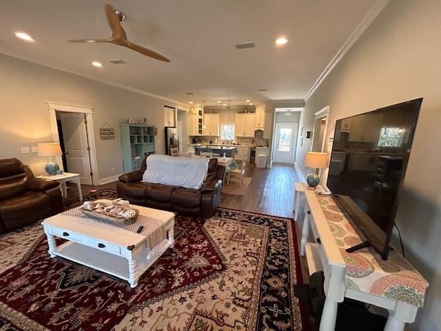 living room with crown molding, ceiling fan, and dark hardwood / wood-style flooring