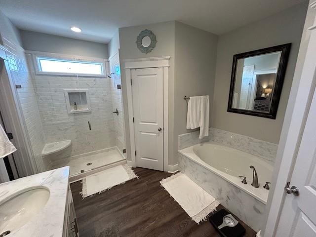 bathroom featuring hardwood / wood-style flooring, vanity, and independent shower and bath