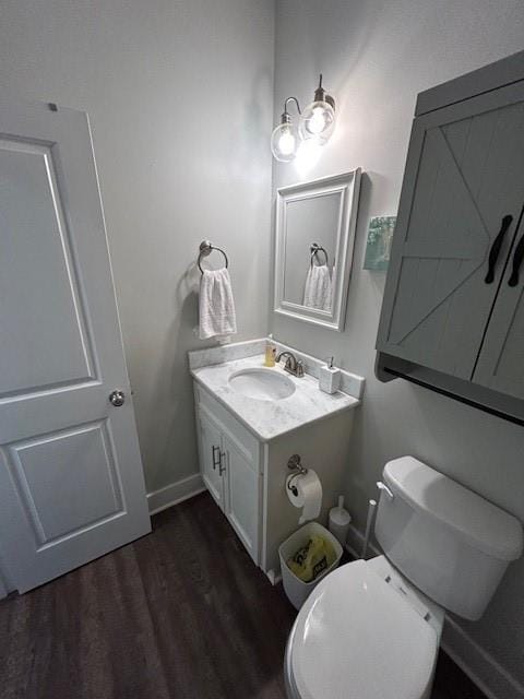 bathroom featuring hardwood / wood-style floors, toilet, and vanity with extensive cabinet space