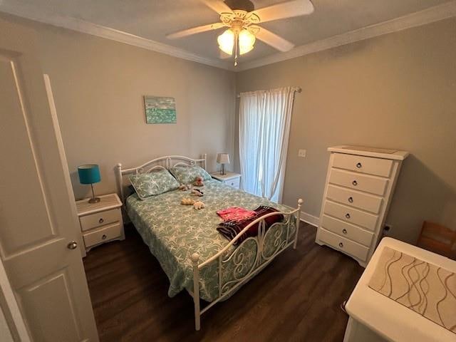 bedroom with crown molding, ceiling fan, and dark hardwood / wood-style flooring