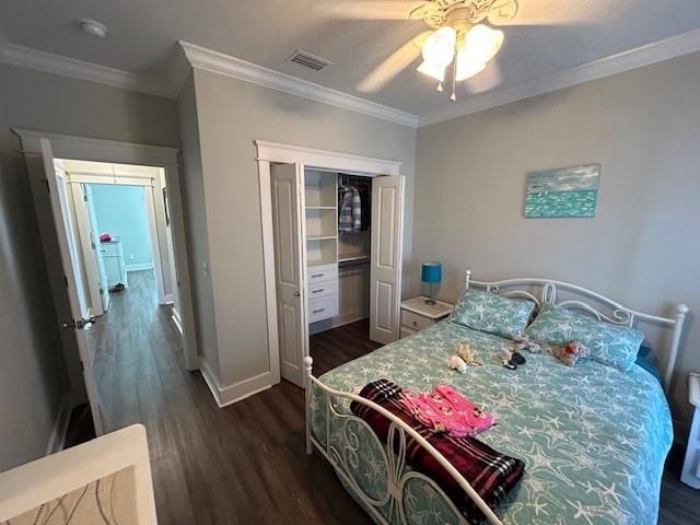 bedroom featuring ceiling fan, crown molding, dark wood-type flooring, and a closet