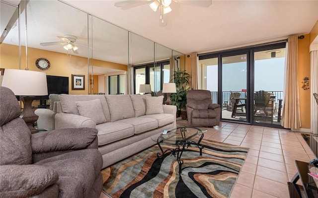 tiled living room featuring ceiling fan and floor to ceiling windows