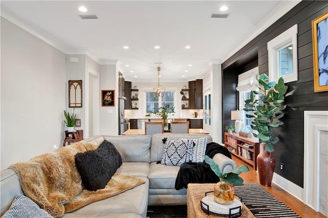 living room featuring recessed lighting, visible vents, crown molding, and wood finished floors