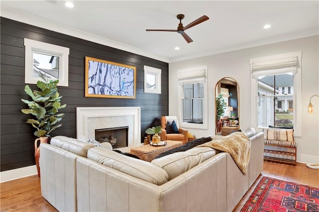 living room with baseboards, ceiling fan, light wood-style floors, a fireplace, and recessed lighting