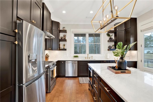 kitchen featuring tasteful backsplash, light wood-style floors, stainless steel appliances, under cabinet range hood, and open shelves