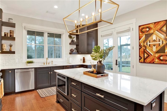 kitchen with dishwasher, backsplash, light wood-style floors, open shelves, and a sink