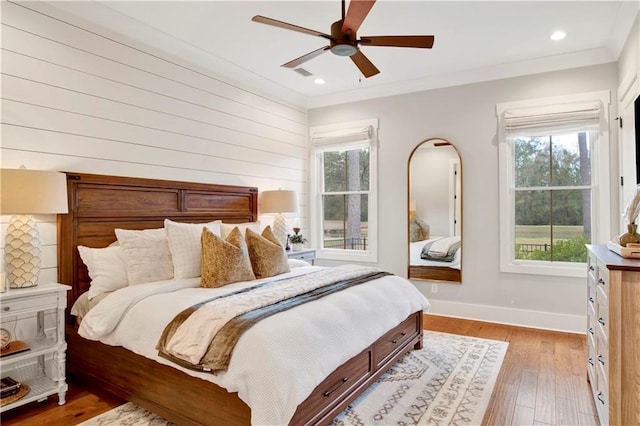 bedroom with crown molding, recessed lighting, light wood-type flooring, and baseboards