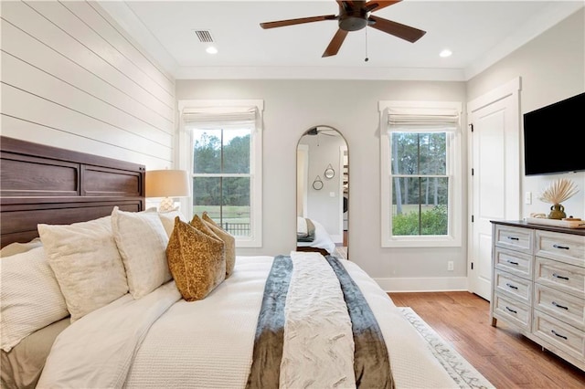 bedroom featuring light wood finished floors, baseboards, visible vents, crown molding, and recessed lighting