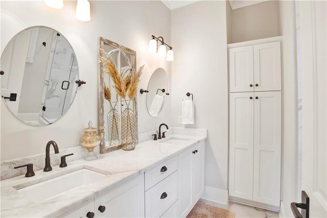 full bathroom featuring double vanity, an enclosed shower, and a sink