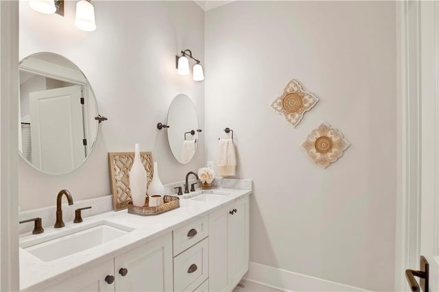 full bathroom with double vanity, a sink, and baseboards