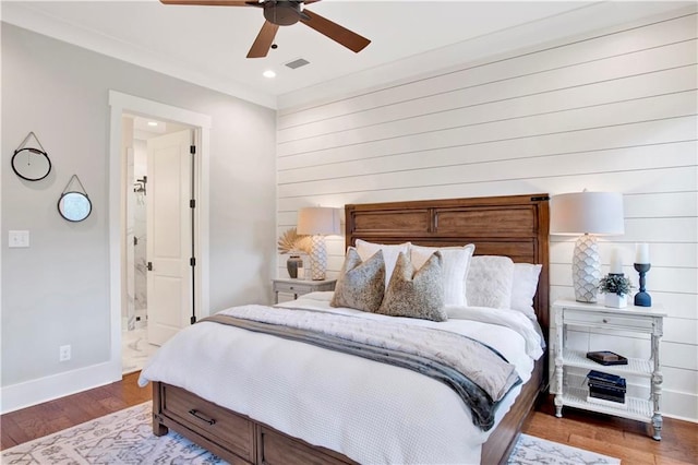 bedroom with baseboards, visible vents, connected bathroom, wood finished floors, and recessed lighting