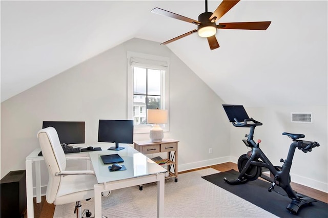 home office featuring lofted ceiling, ceiling fan, wood finished floors, visible vents, and baseboards