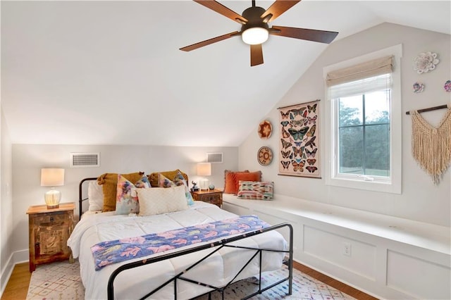 bedroom featuring light wood-style floors, lofted ceiling, visible vents, and ceiling fan