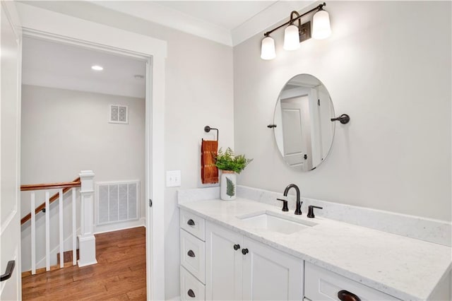 bathroom with visible vents, vanity, and wood finished floors