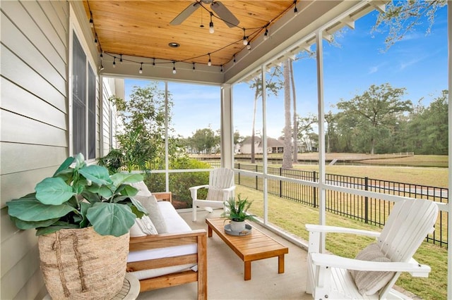 sunroom with wooden ceiling, rail lighting, and a ceiling fan