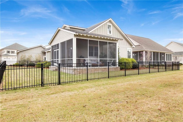 back of house with a yard, board and batten siding, fence, and a sunroom