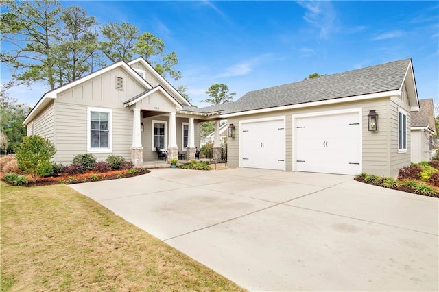 craftsman inspired home with roof with shingles, a porch, concrete driveway, board and batten siding, and a front lawn