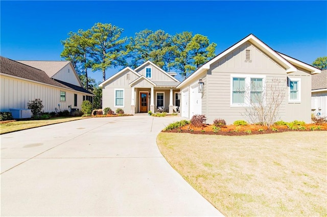 view of front facade with driveway, an attached garage, a front lawn, and board and batten siding