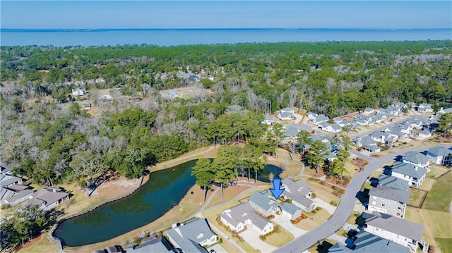 birds eye view of property featuring a forest view, a water view, and a residential view