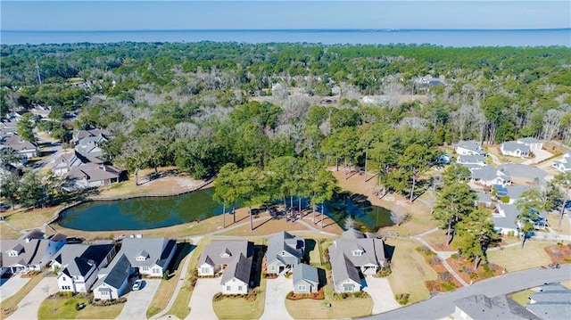 drone / aerial view with a water view, a residential view, and a view of trees