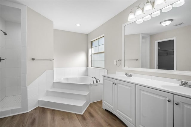 bathroom with hardwood / wood-style flooring, vanity, and separate shower and tub